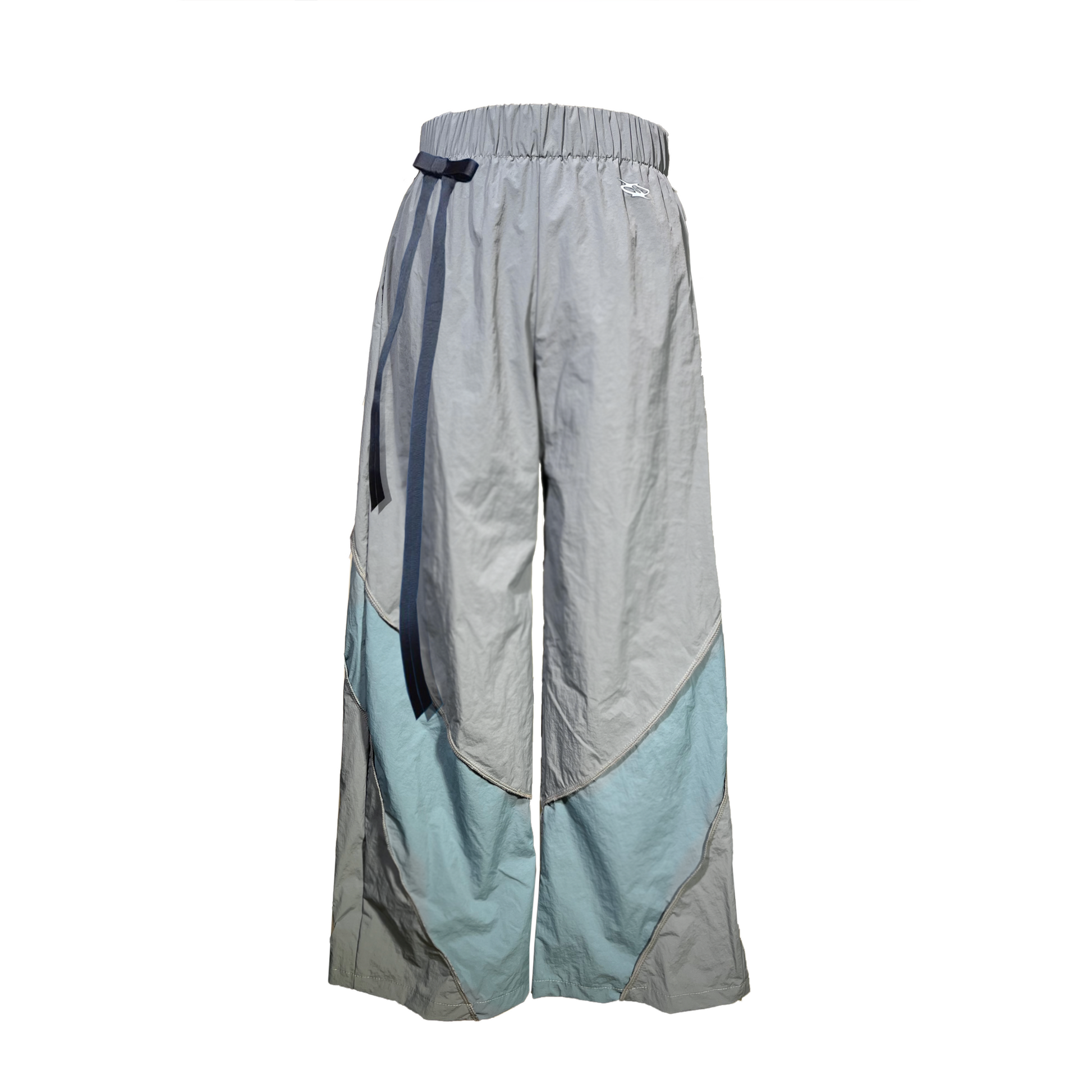 High waisted loose fitted track pants.
Wide bottom hem for extrem loose fit.
Elastic waistband and side pockets.
Blue panels going from the back to the front.
Inside out stitching detailing.
Bow under the waistband on the right upper hip.
Me dic al Print logo on the left side.